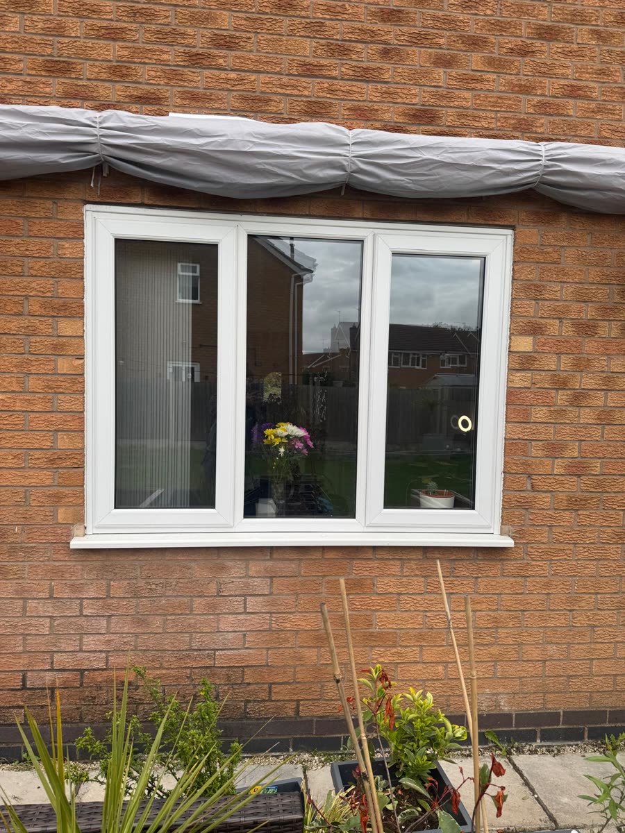 White uPVC three-pane casement window with a matching sill, fitted by URG